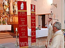 Die Fahnenbänder, die Jubel- u. Partnerwehr sich zum Jubiläum übereignen, segnet Pfarrer Wolfgang Hann von Weyhern